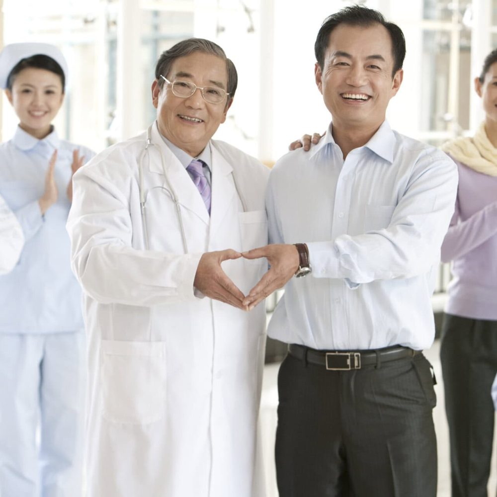 Chinese man doing a heart shape with senior doctor